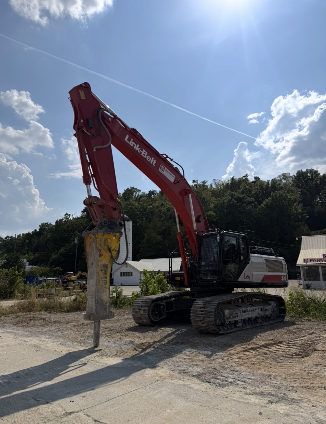 Large excavator fitted with a hydraulic hammer on a job site